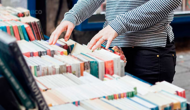 Mãos femininas mexendo em um balcão com livros.